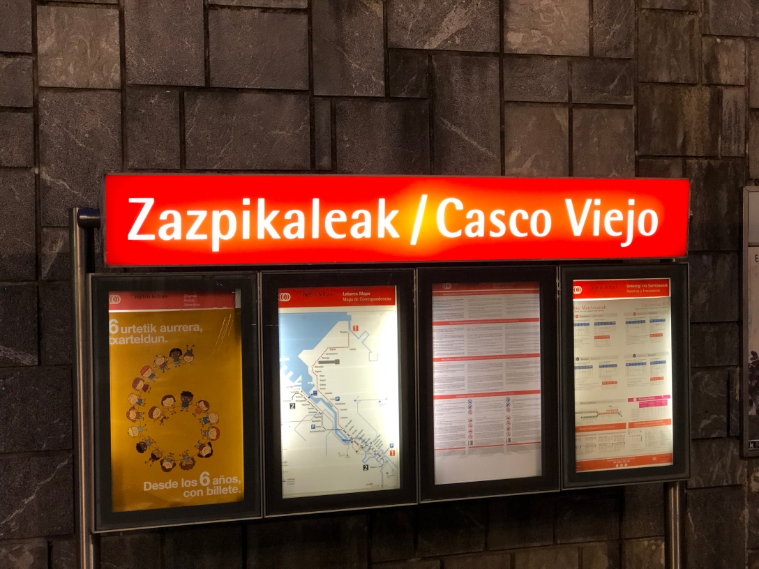 Placa de la estación de metro Zazpikaleak / Casco Viejo. Literalmente, el euskera «zazpi kaleak» significa tanto como «las siete calles». Una referencia a las siete calles que históricamente formaron el Casco Viejo.